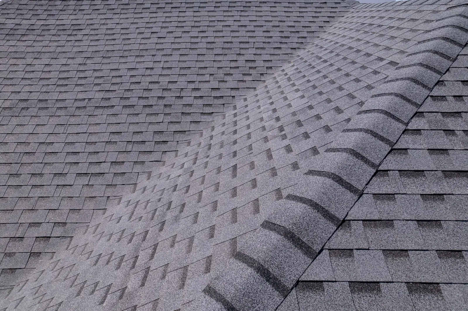 Close-up of new architectural asphalt shingles along a ridge